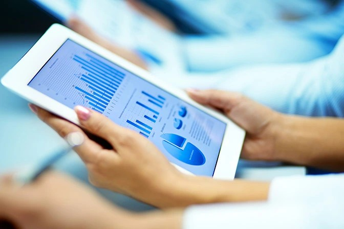 Aerial view of Port of Los Angeles cranes, ships, and dredging equipment under clear skies