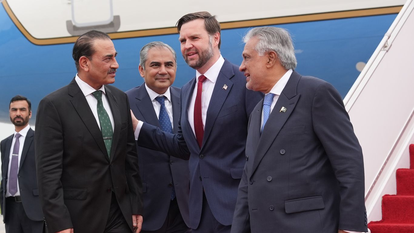 US and Iranian diplomats shaking hands at negotiation table in Islamabad with Pakistani officials