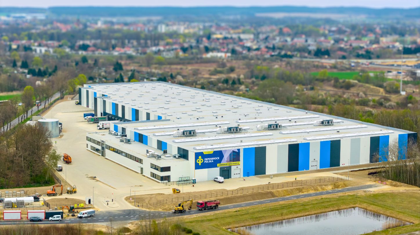Exterior view of a large, modern industrial warehouse building with loading docks.
