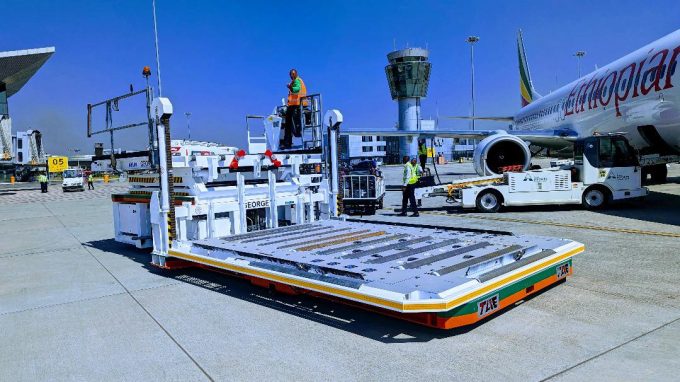 An illustration of a large cargo airplane being loaded at an airport terminal.