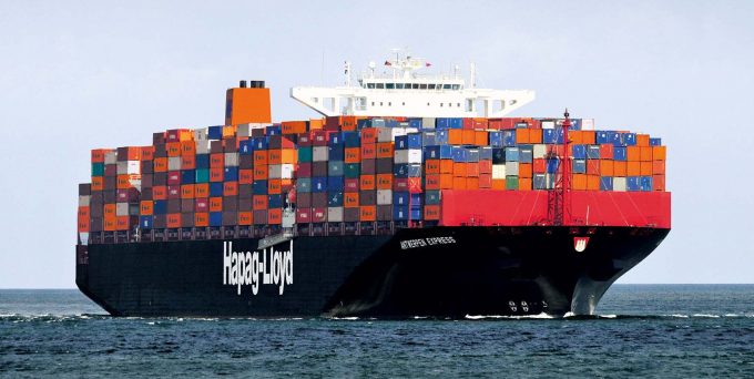 A container ship sailing through a calm sea, with a subtle overlay indicating rising fuel prices.