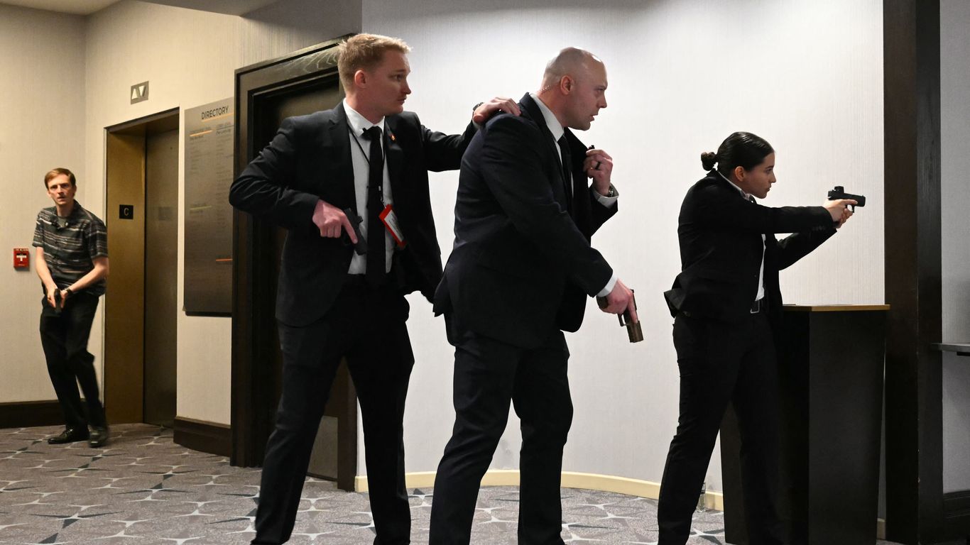 President Trump being escorted out of a ballroom by Secret Service agents.