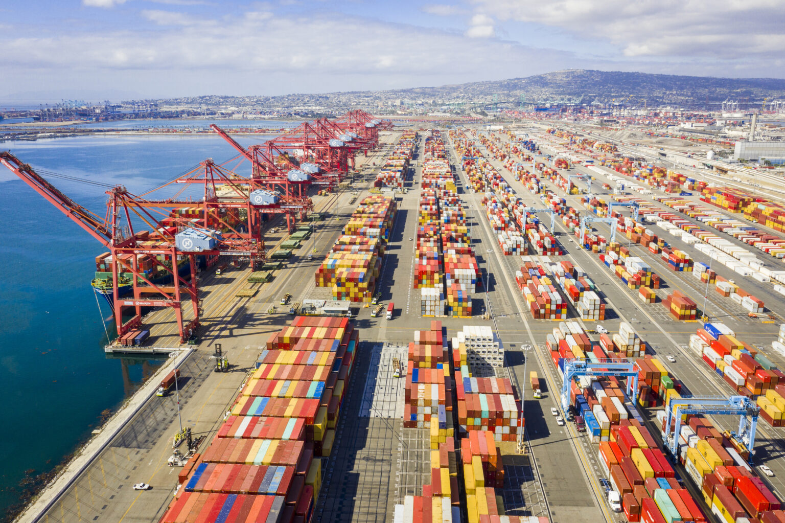 Container ships navigating a busy port, with cargo cranes visible.