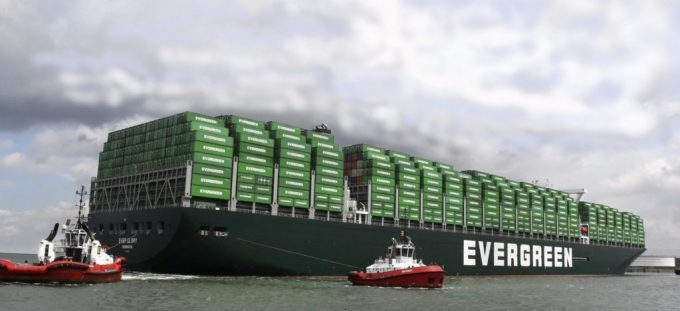 Evergreen container ship sailing on the ocean with a blue sky.