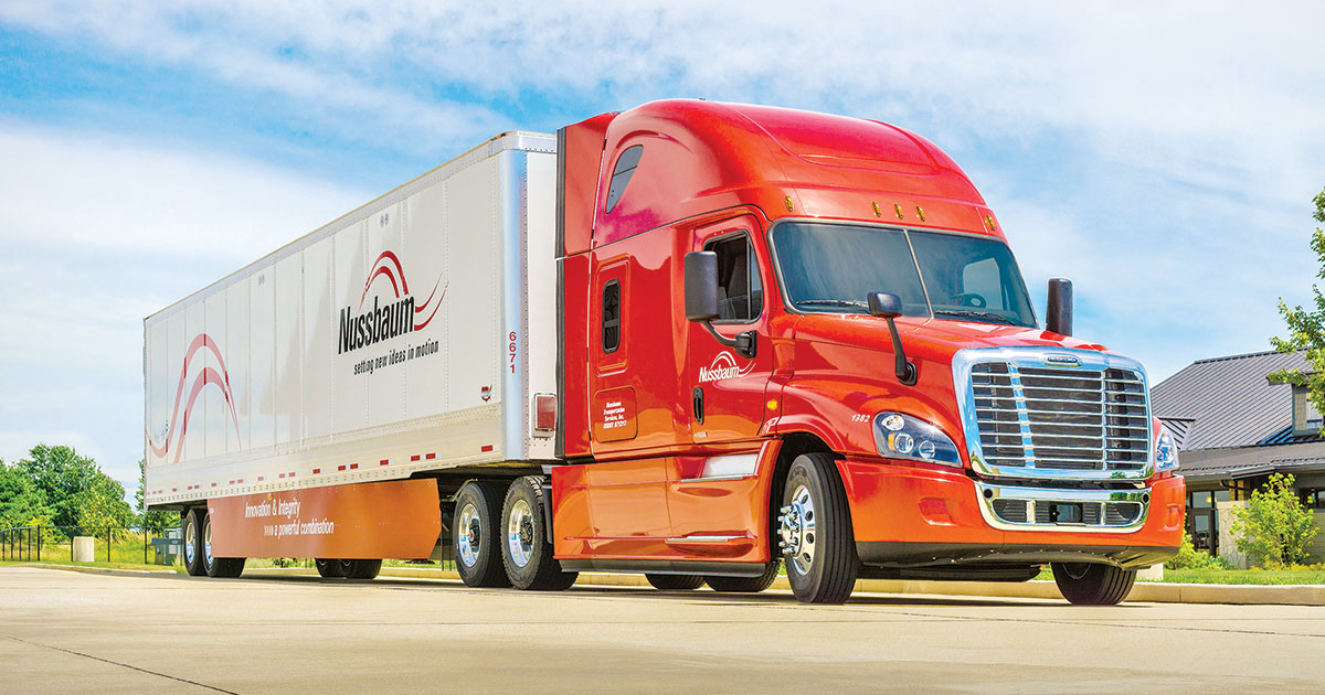 A Nussbaum Transportation truck driving on a highway at sunset.