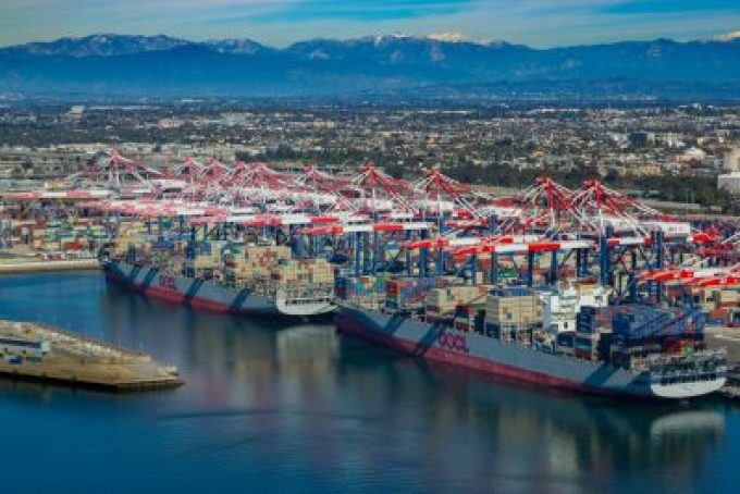 Container ships docked at a busy port with cranes loading and unloading cargo.