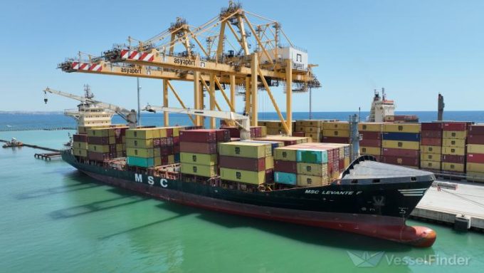 A large container ship sailing on the ocean, with MSC branding visible.