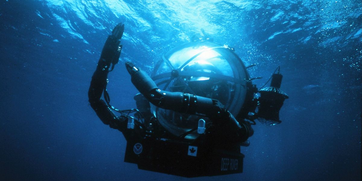 Deep Rover submersible pilot in acrylic bubble dome surrounded by deep-sea life