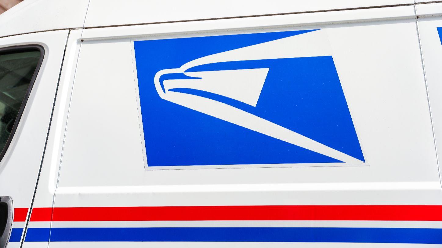 USPS Priority Mail parcels stacked with price adjustment notice overlay