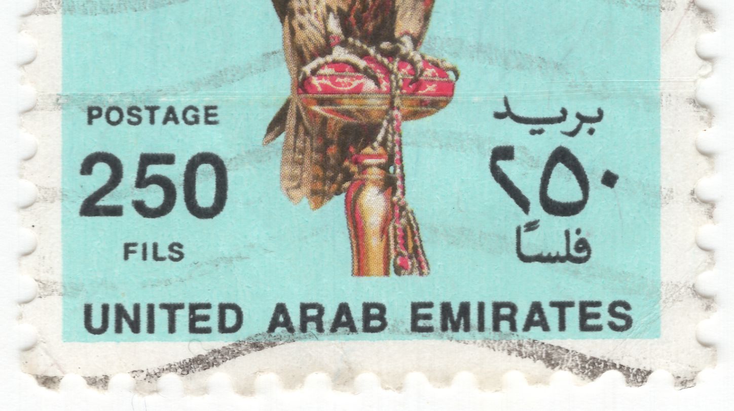A hand stamping a package with a UAE postal service logo.