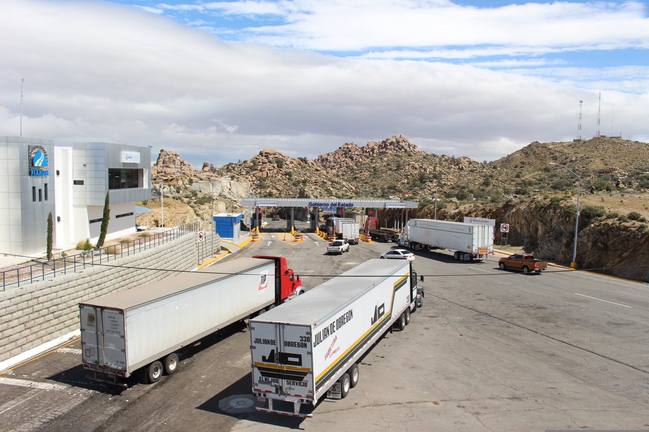 Aerial view of a congested border crossing with long lines of trucks.