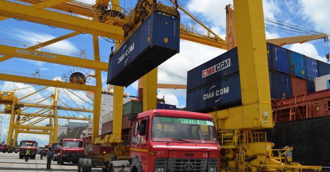 Aerial view of a busy container port with ships being loaded and unloaded.