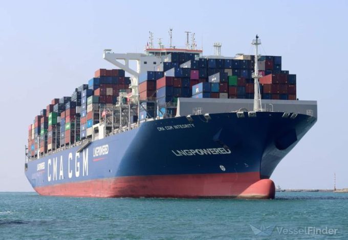A container ship sailing on a busy sea, with stacks of shipping containers visible.