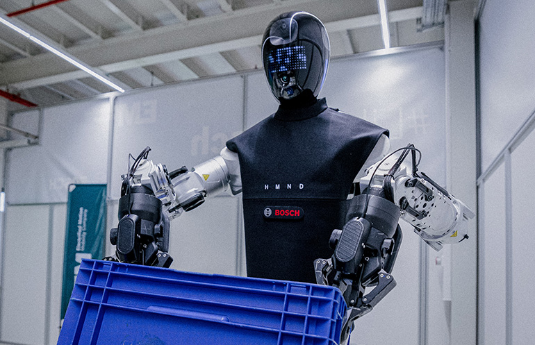A humanoid robot arm precisely placing a box onto a trolley in a warehouse setting.