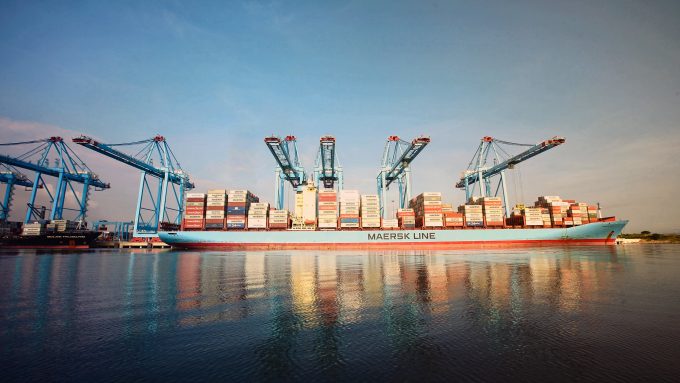 Aerial view of a busy shipping port with many containers and cranes.