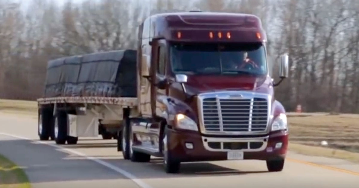 A Maverick truck driving down a highway at sunset