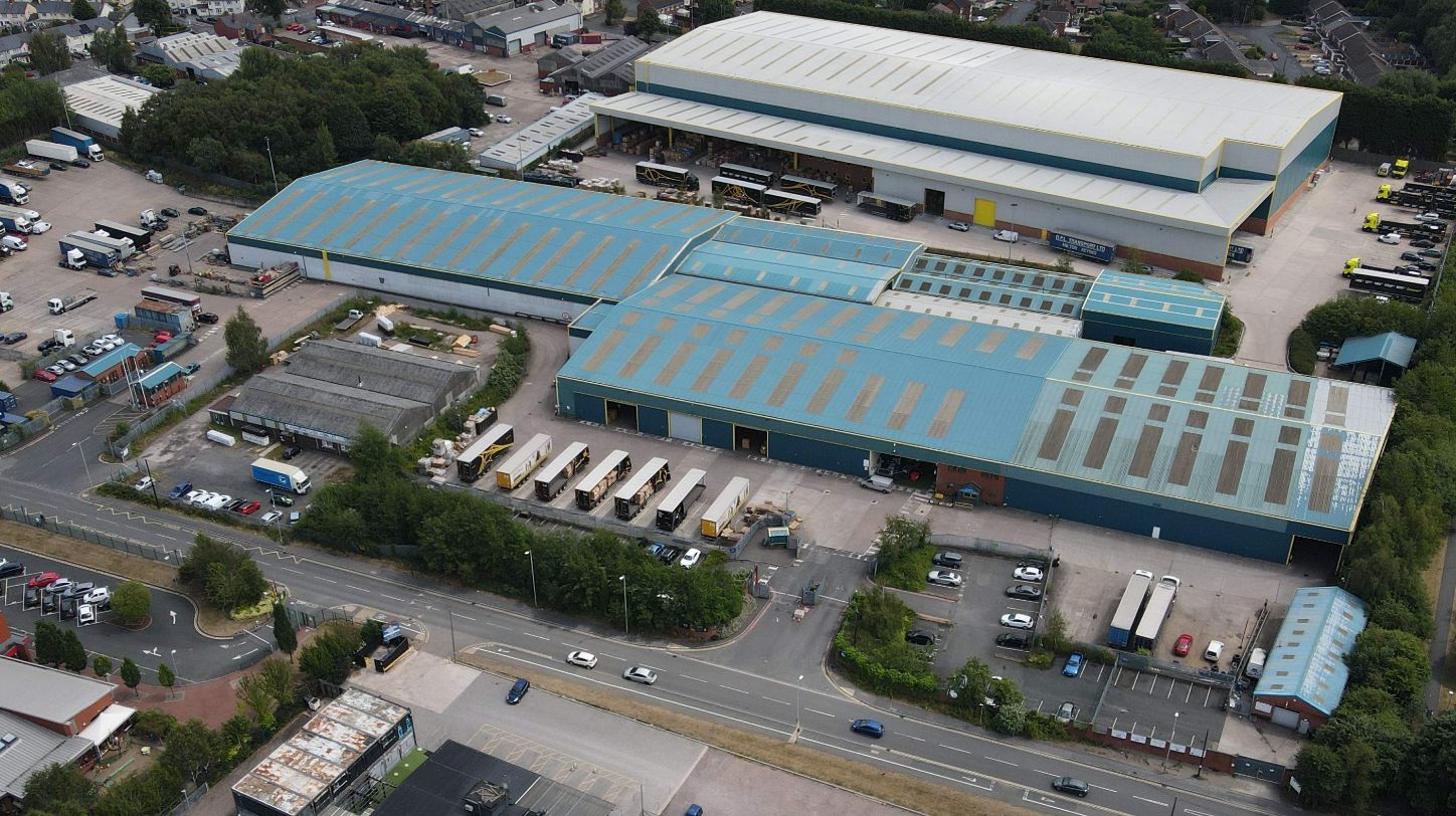 Aerial view of a large modern logistics facility with extensive yard space and truck parking.