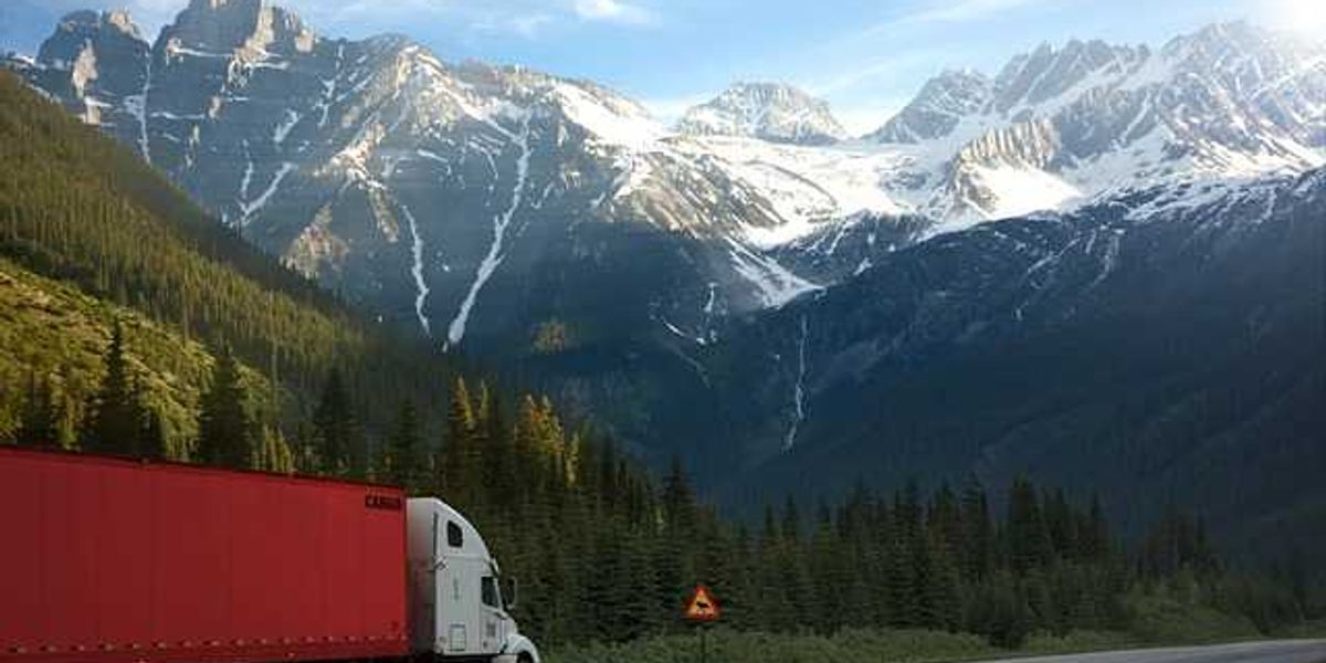 A semi-truck on a highway with a rising graph superimposed over it.