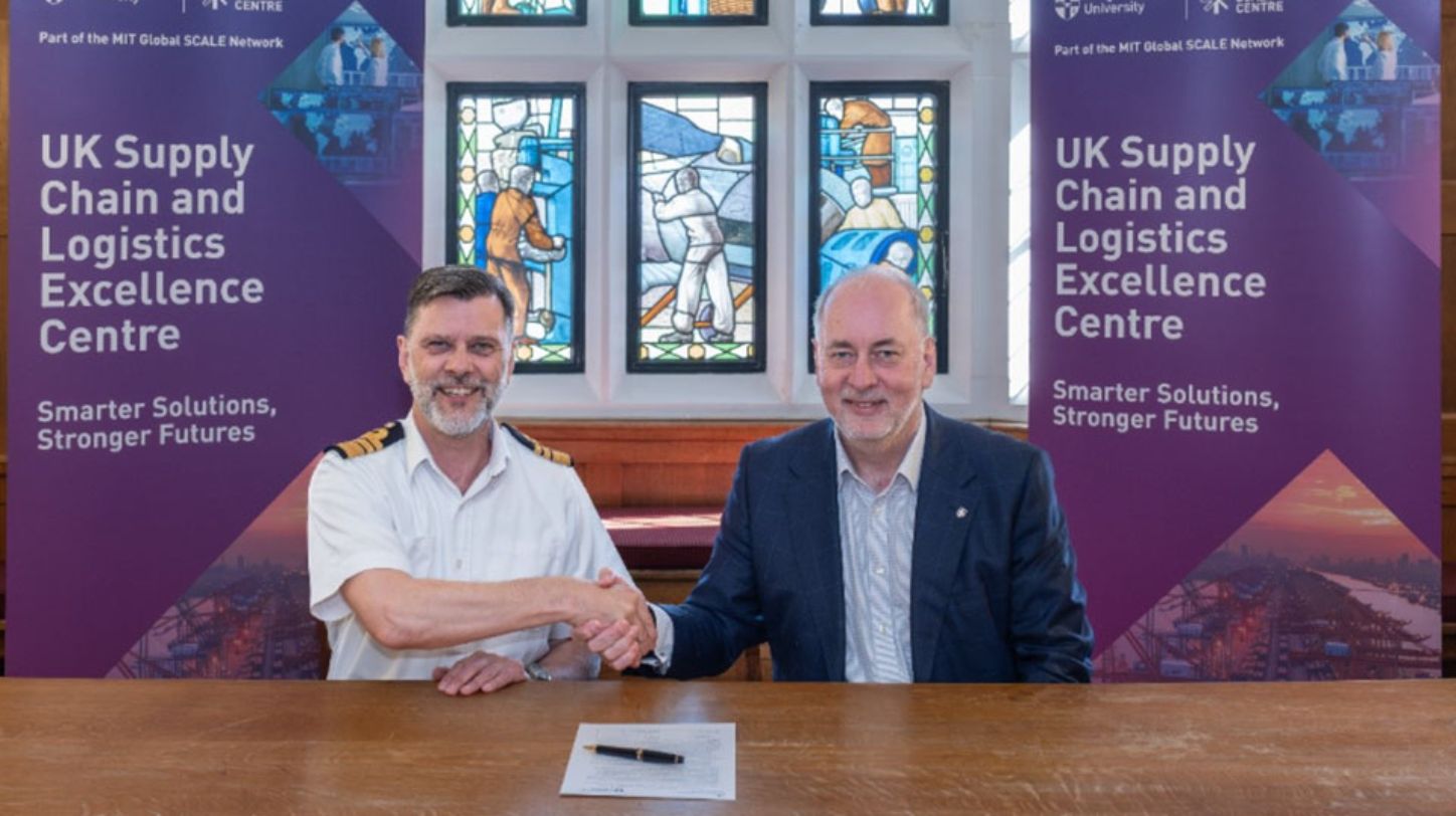 A hand signing a document, representing a partnership agreement.