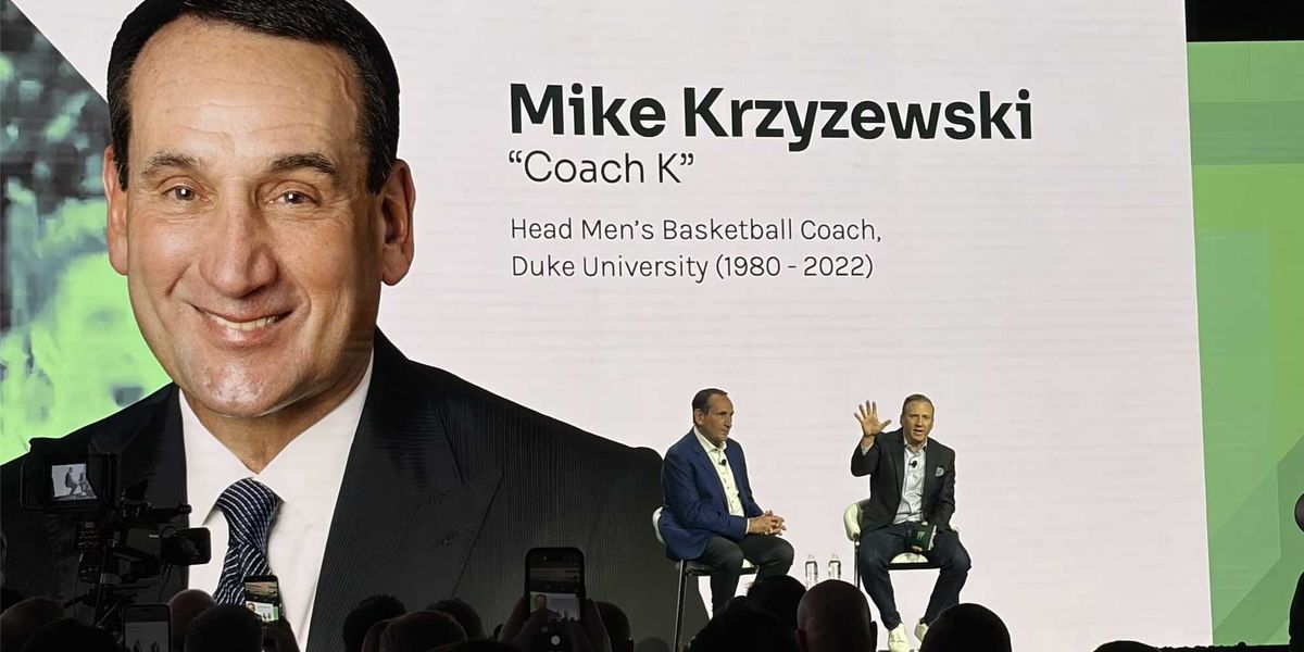 Mike Krzyzewski speaking on a stage at a conference
