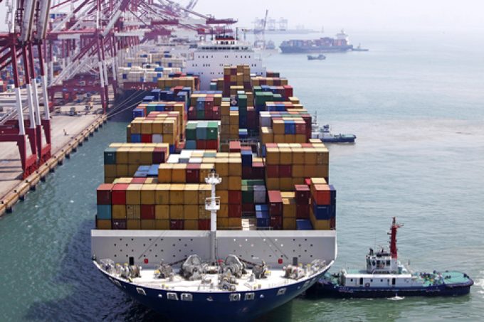 A container ship at sea, loaded with numerous shipping containers.